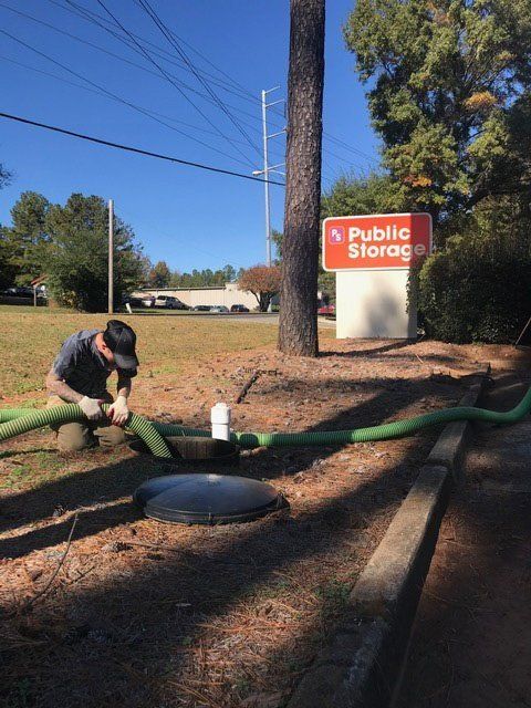 Man Fixing The Hose Two — Statham, GA — Affordable Septic Service