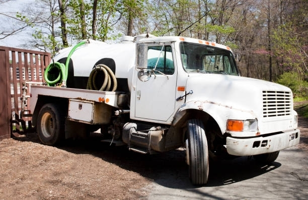 Septic tank system cleaning truck parked outside a property.