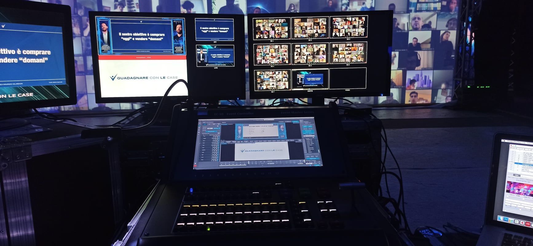 Una sala di controllo televisiva con più monitor che mostrano feed video e un pannello di controllo.