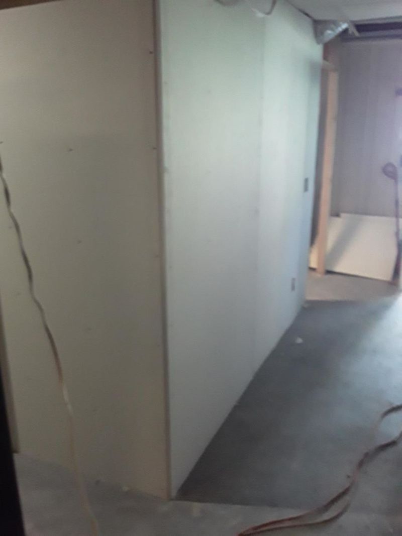 Drywall wall construction in a room, concrete floor, light.
