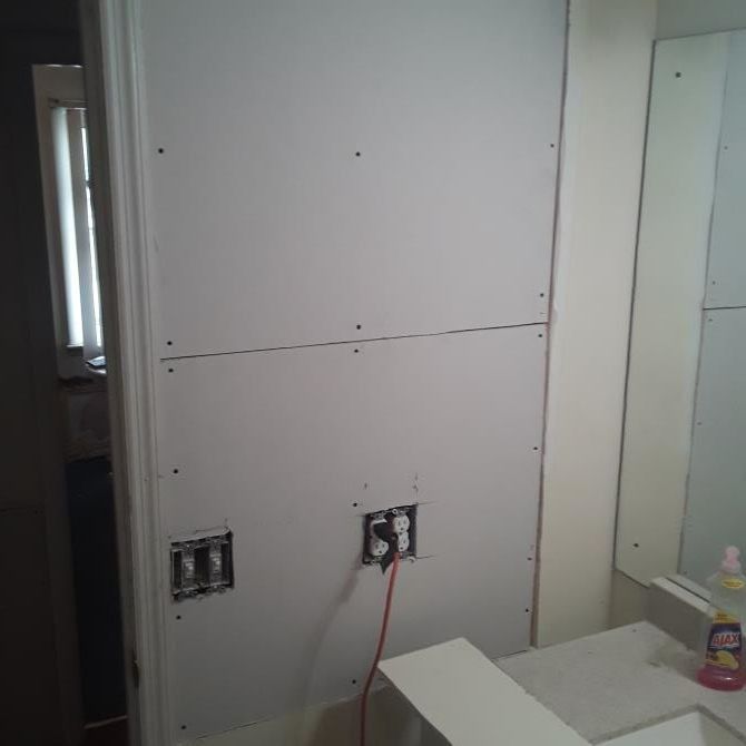 Interior wall under construction with drywall, outlets, and sink visible.