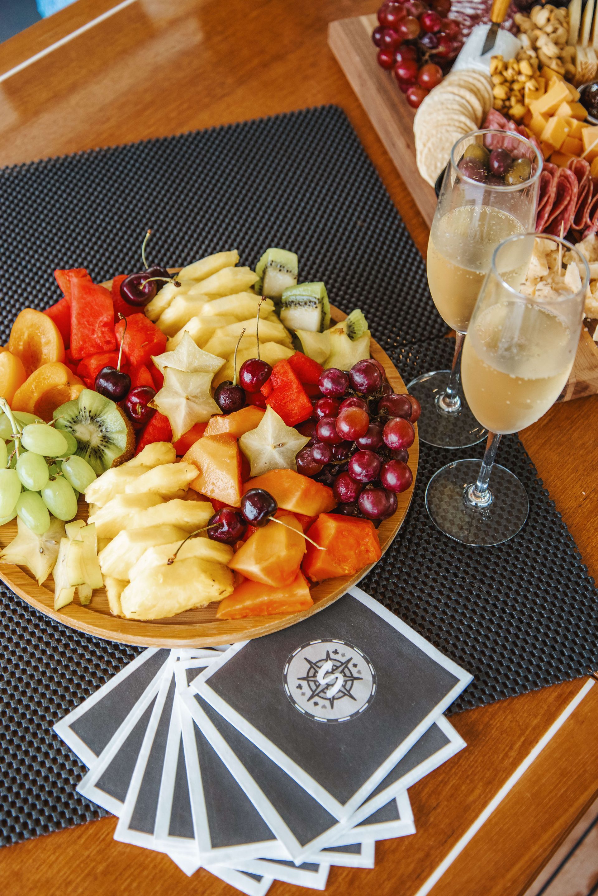 Fruit platter with champagne glasses and a charcuterie board.