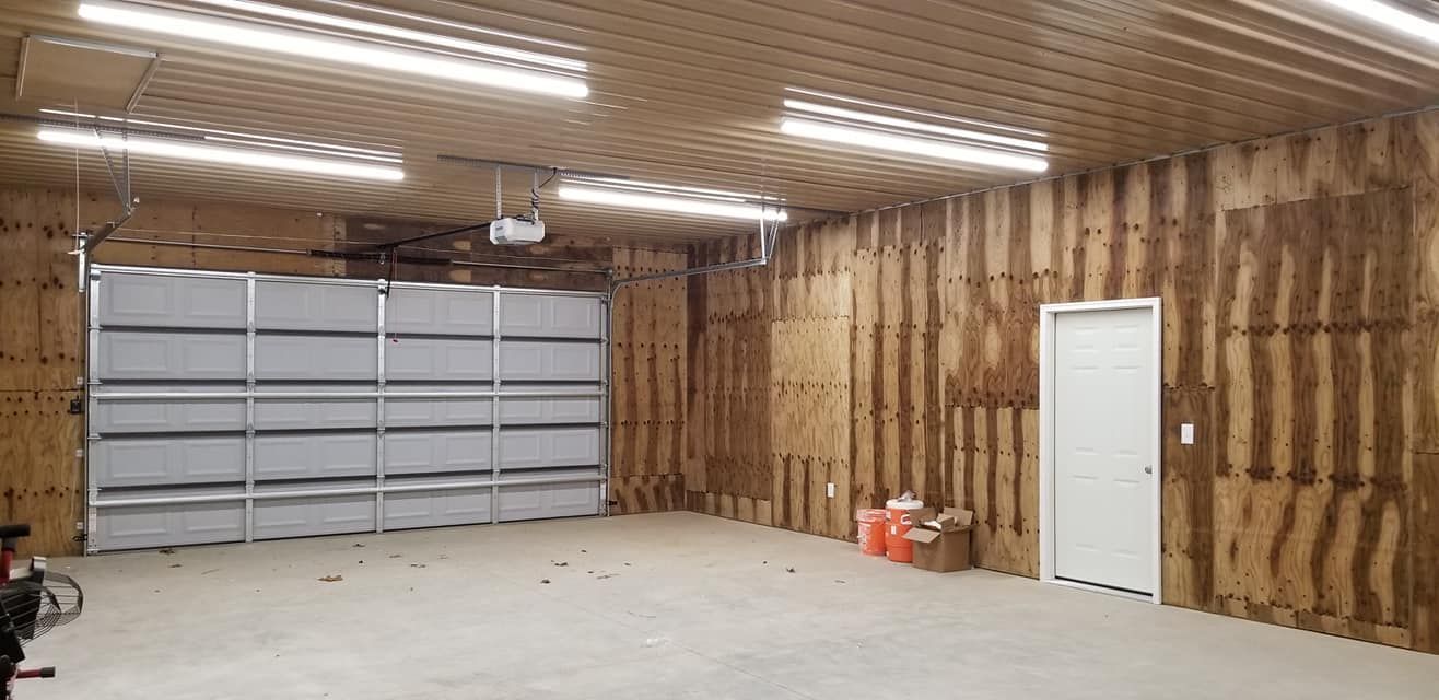 A garage with a large garage door and wooden walls.
