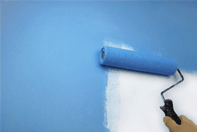 A white wall being painted blue with a paint roller