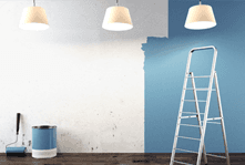 A stepladder and a pot of paint in front of a white wall half-painted blue