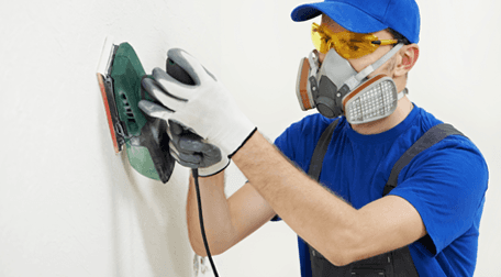 A plasterer at work wearing protective mask