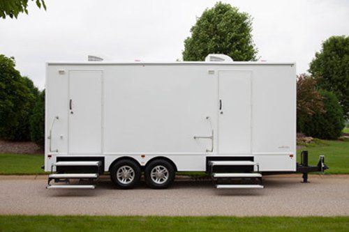 A white trailer is parked on the side of a road. A white trailer is parked on the side of a road.