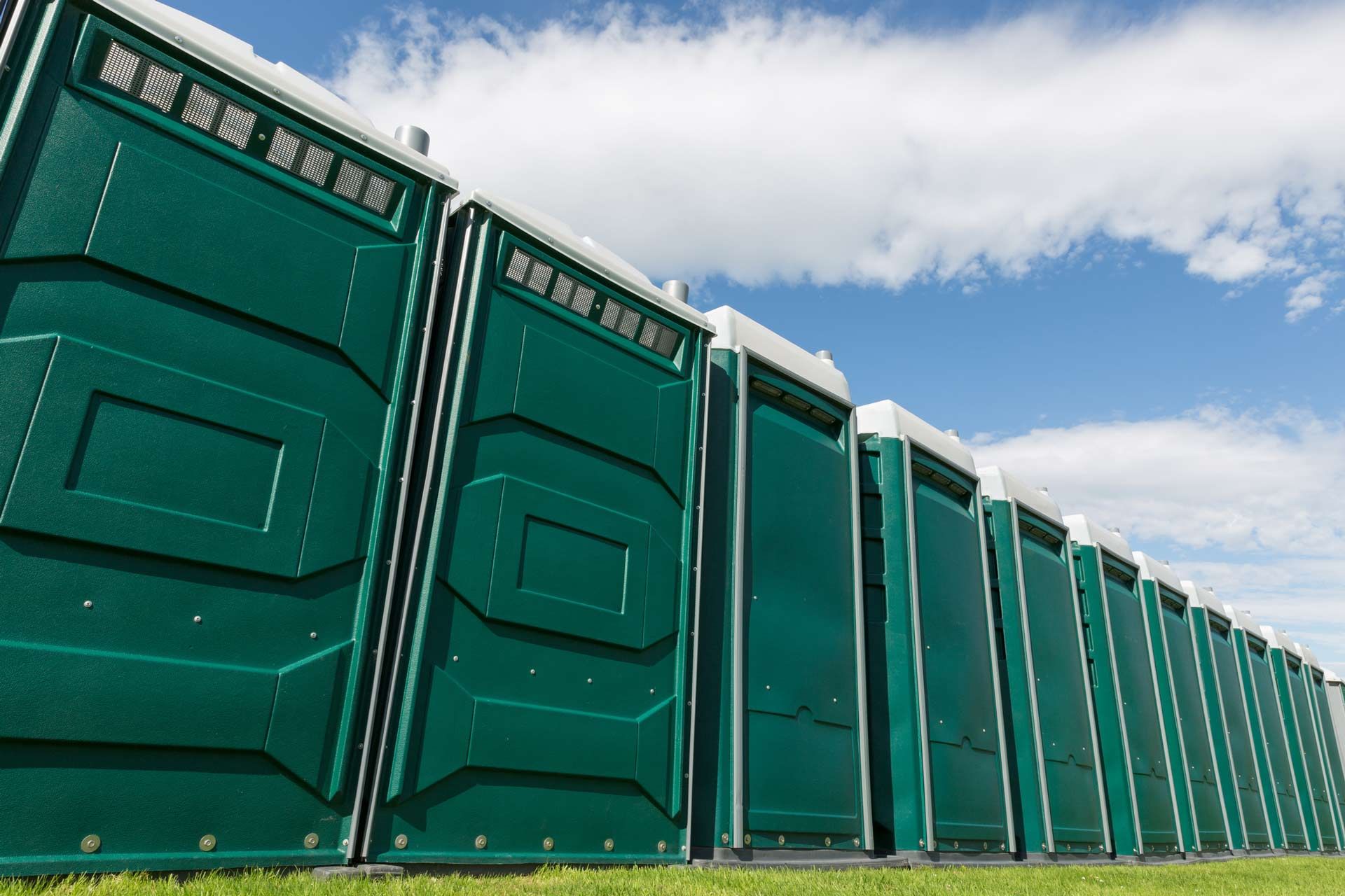 Portable toilet rental units lined up in a field for outdoor event use - Pensacola, FL - Gotta Go Site Service Rentals Portable toilet rental units lined up in a field for outdoor event use - Pensacola, FL - Gotta Go Site Service Rentals