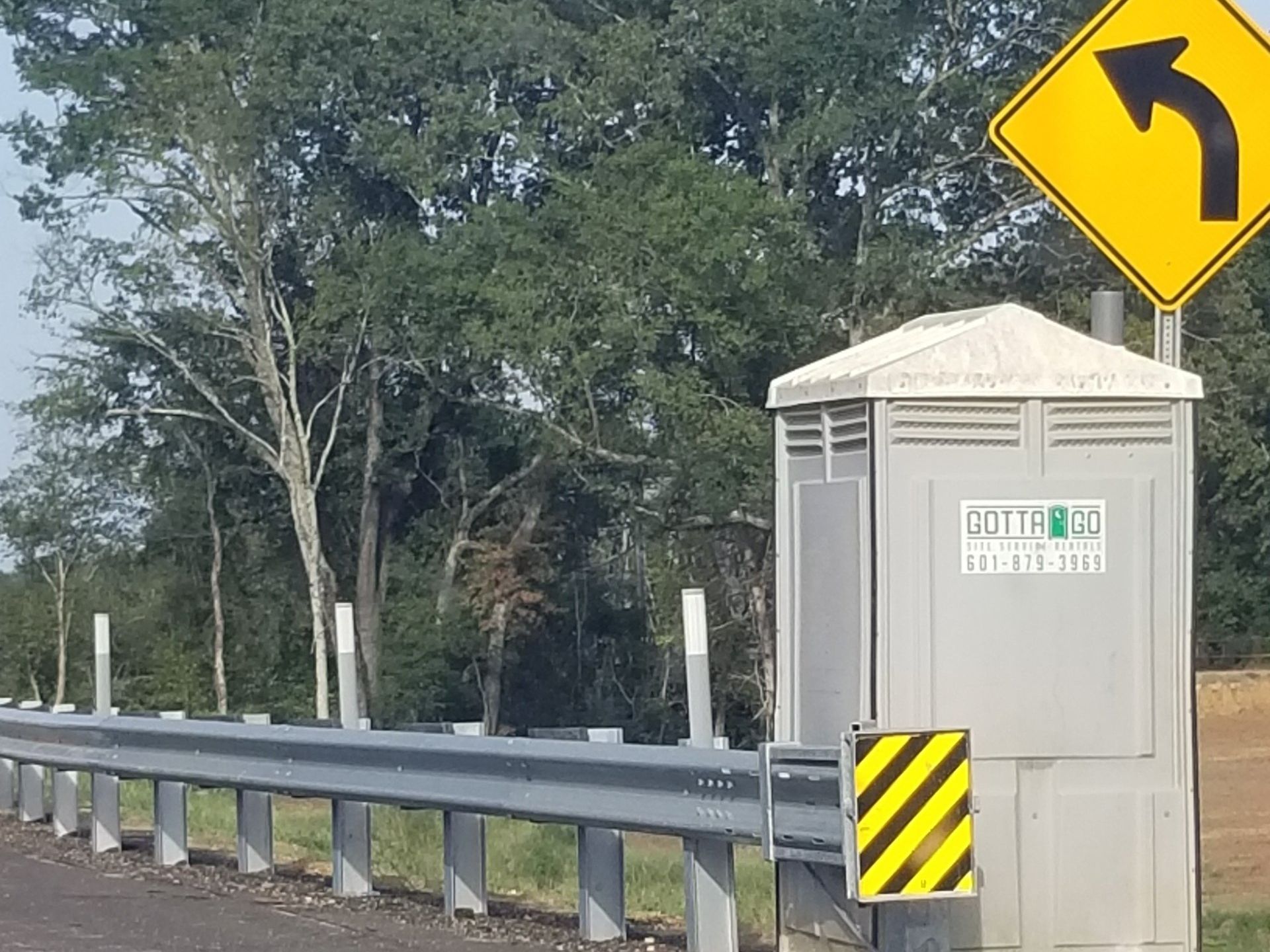 A portable toilet next to a highway sign  — Meridian, MS — Gotta Go Site Service Rentals