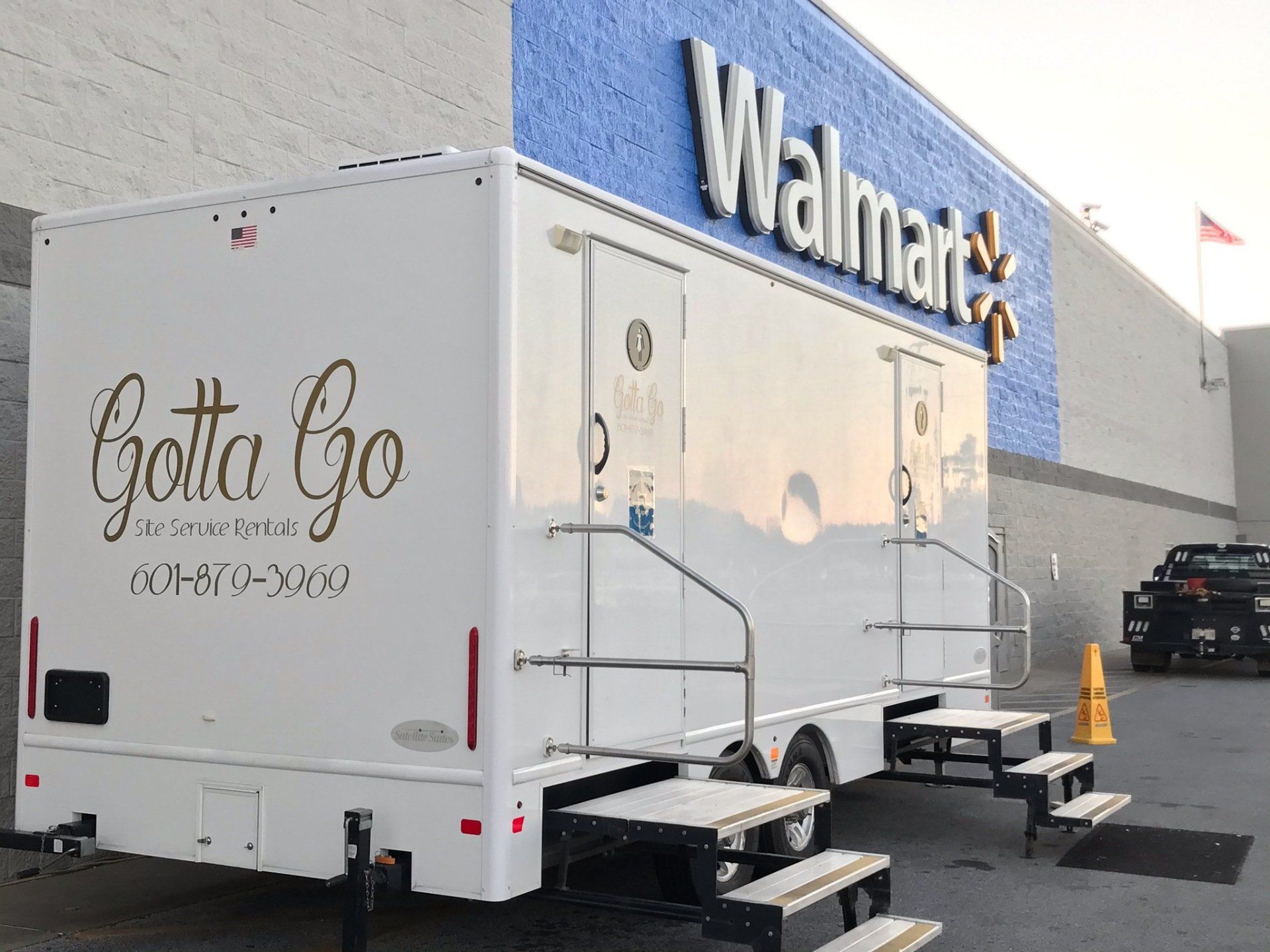 A white trailer is parked in front of a walmart store. A white trailer is parked in front of a walmart store.