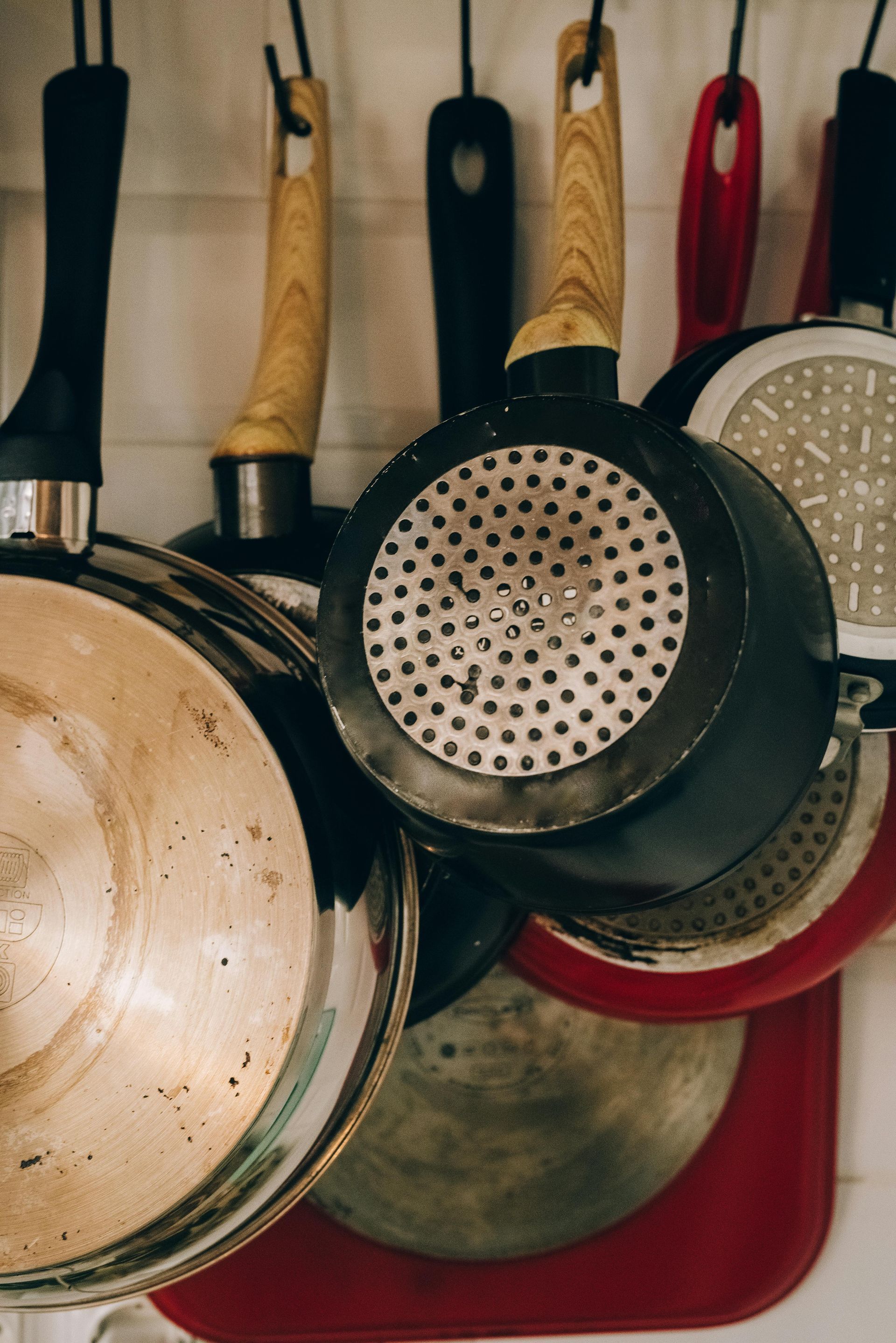 A bunch of pots and pans hanging on a wall.