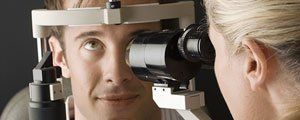 Glaucoma Treatment — Optometrist Doing Sight Testing for Patient in Hutchinson, KS