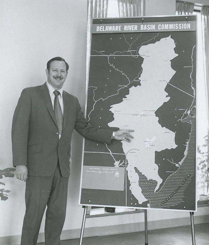 This is placeholder text.Gerald Hansler, the Delaware River Basin Commission's second executive director, points to a map of the Delaware River Basin.