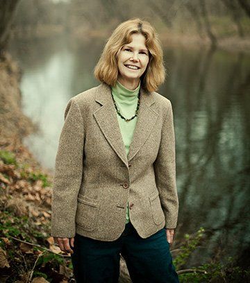 Carol Collier, the Delaware River Basin Commission's third executive director, is shown standing along a riverbank.
