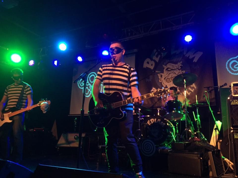 A man is standing on a stage playing a guitar.