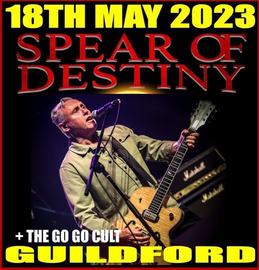 A man is singing into a microphone while holding a guitar ..