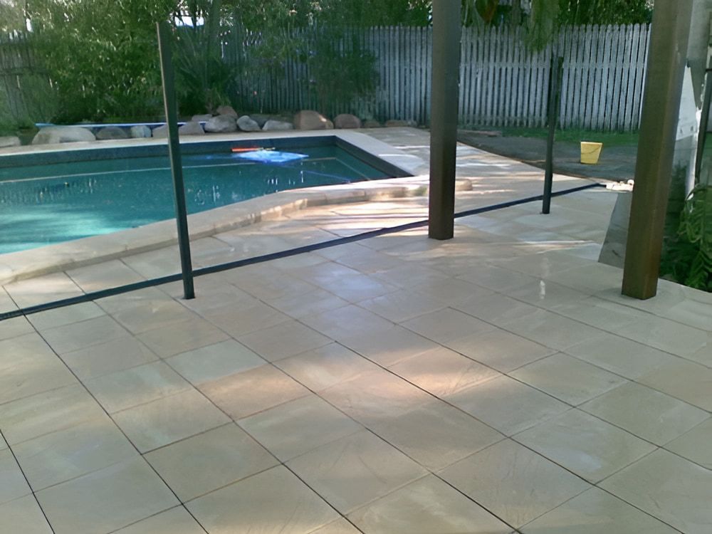 A Large Swimming Pool Is Surrounded By A Tiled Deck — Baker & Co. Landscape Construction In Gulliver, QLD