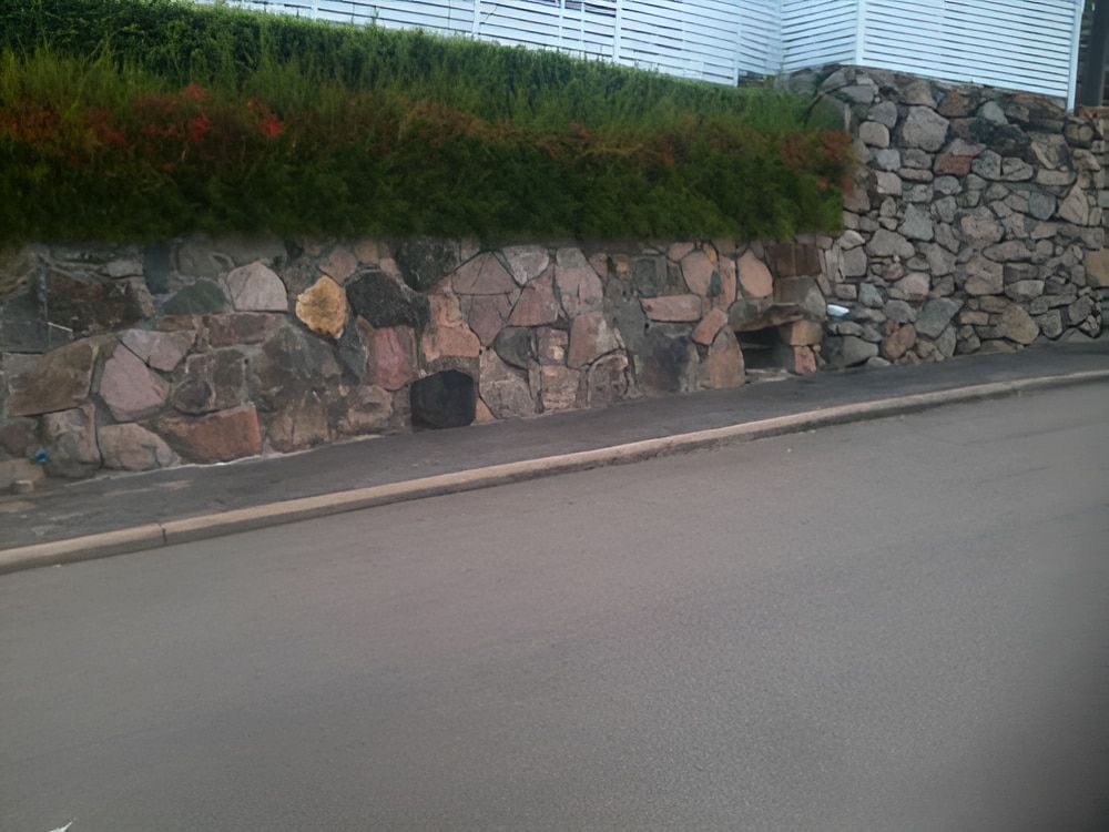 A Stone Wall Along The Side Of A Road — Baker & Co. Landscape Construction In Gulliver, QLD