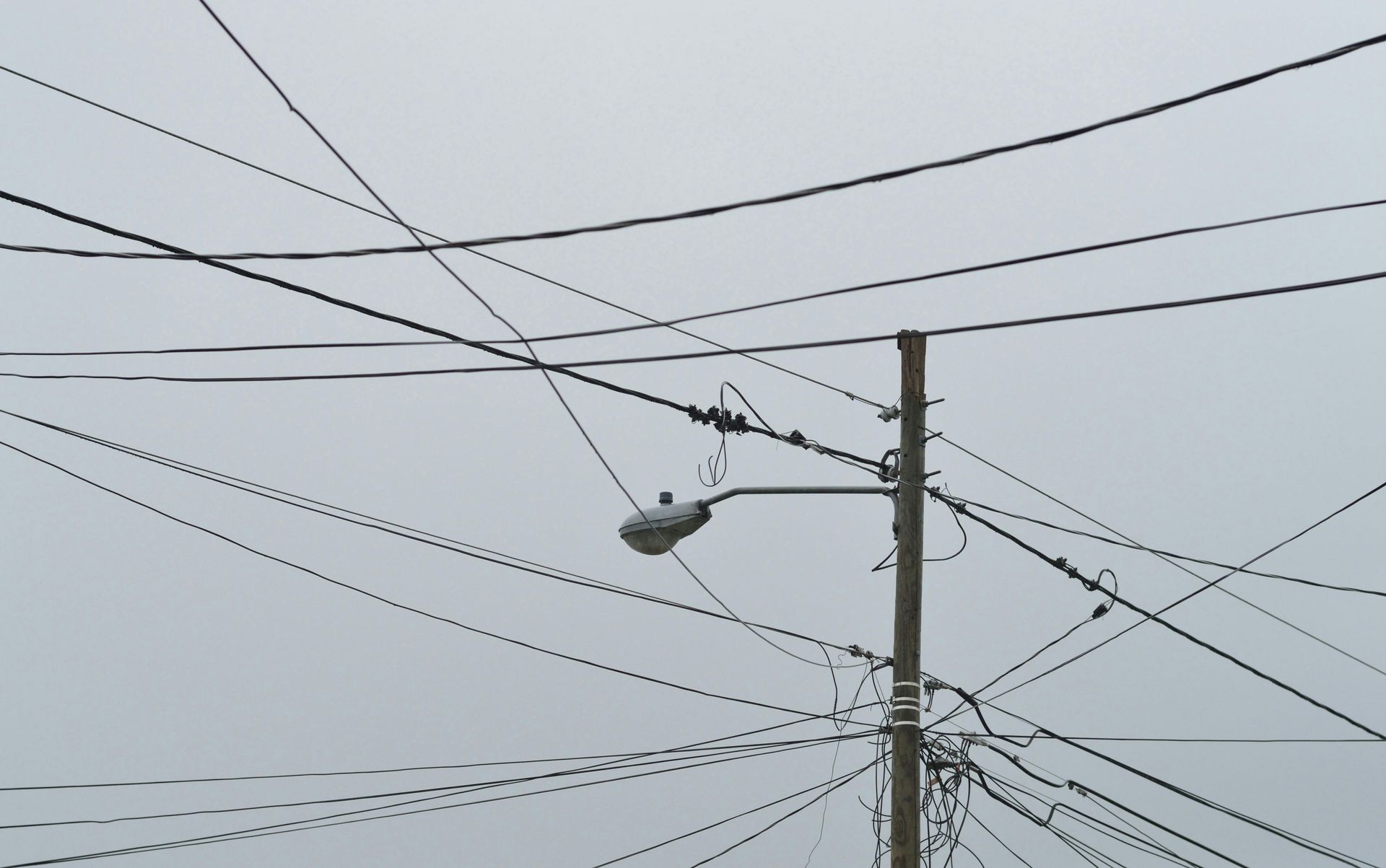 A street light is hanging from a power line