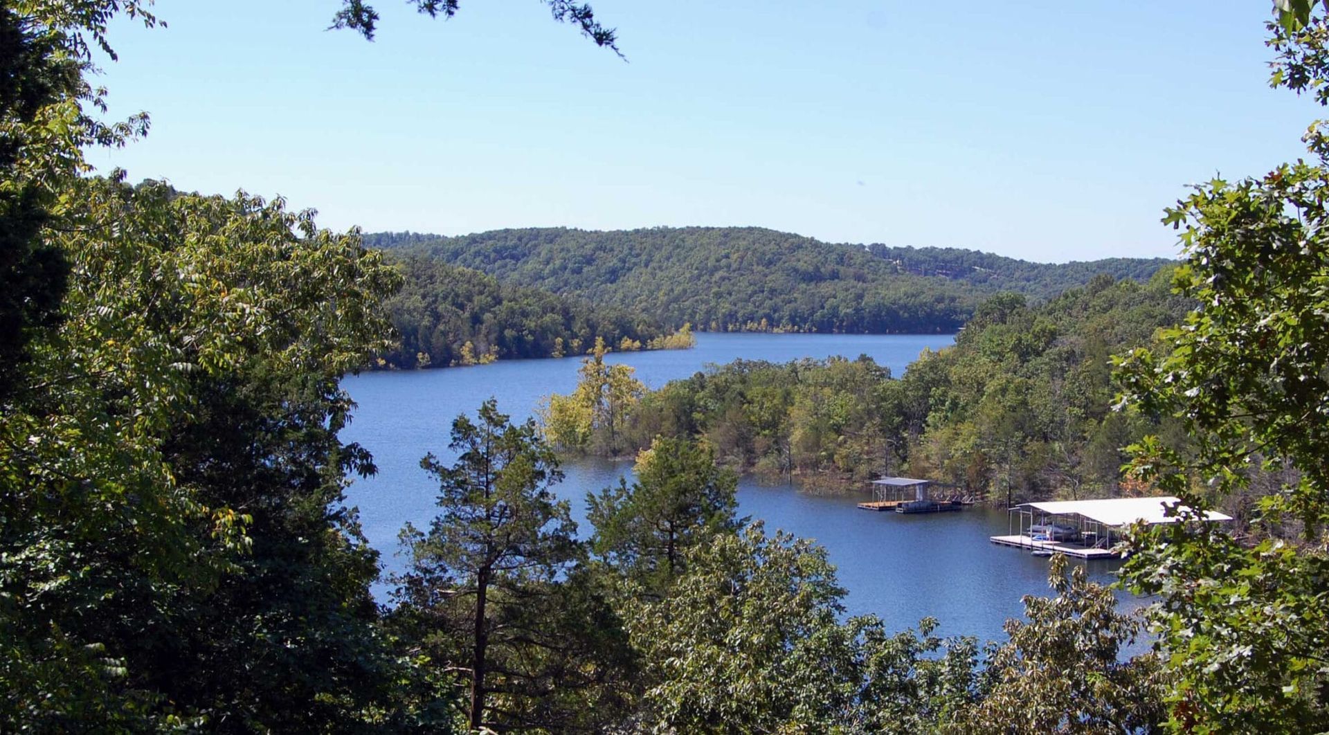 A view of a lake surrounded by trees on a sunny day