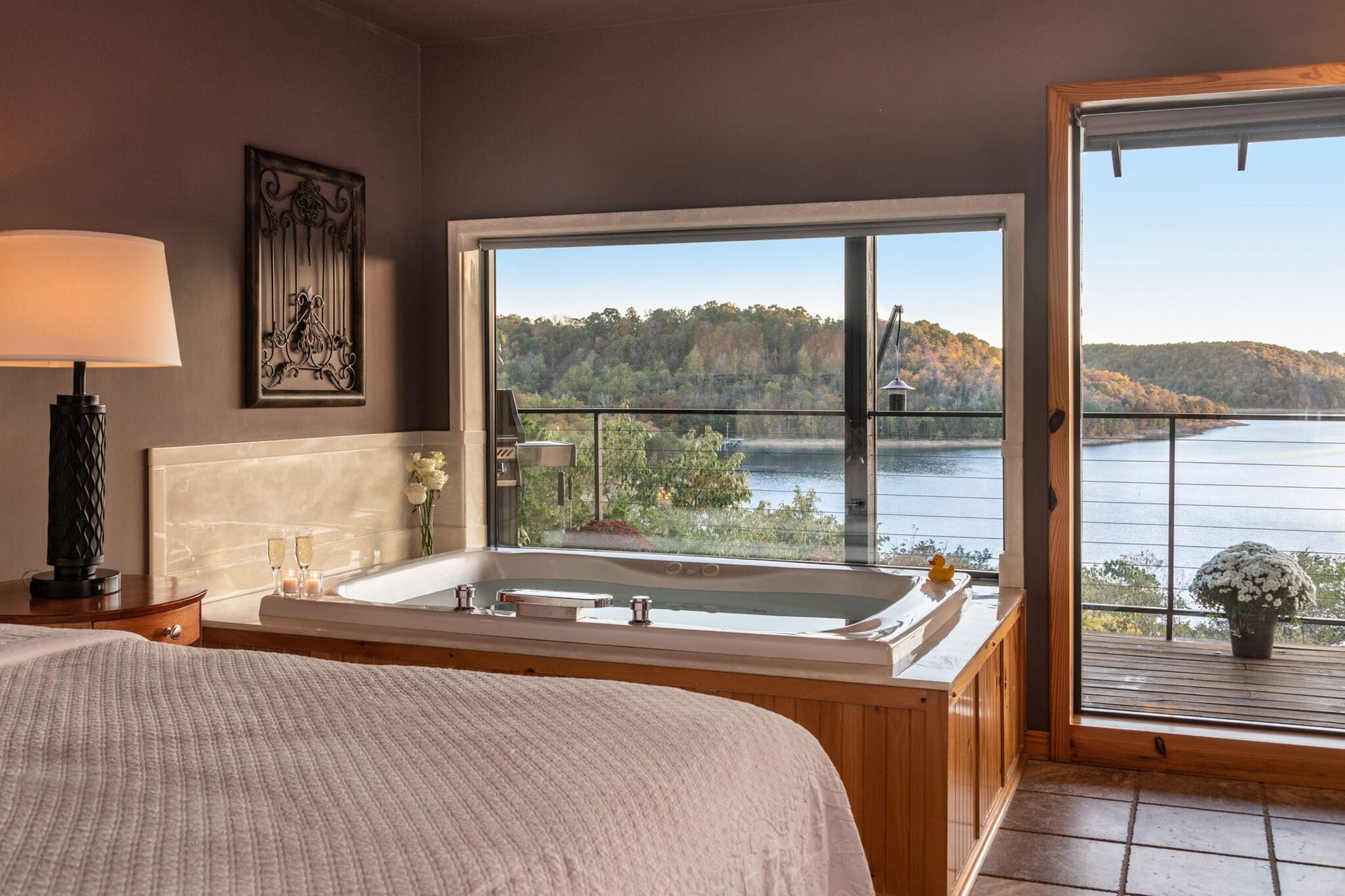 A bedroom with a jacuzzi tub and a view of a lake