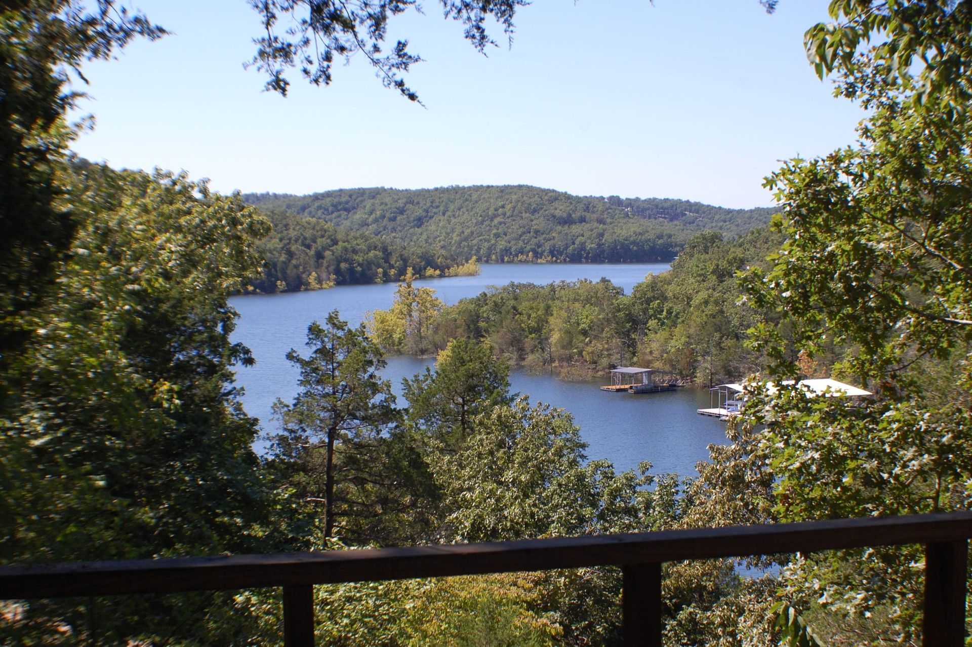 A view of a lake surrounded by trees on a sunny day