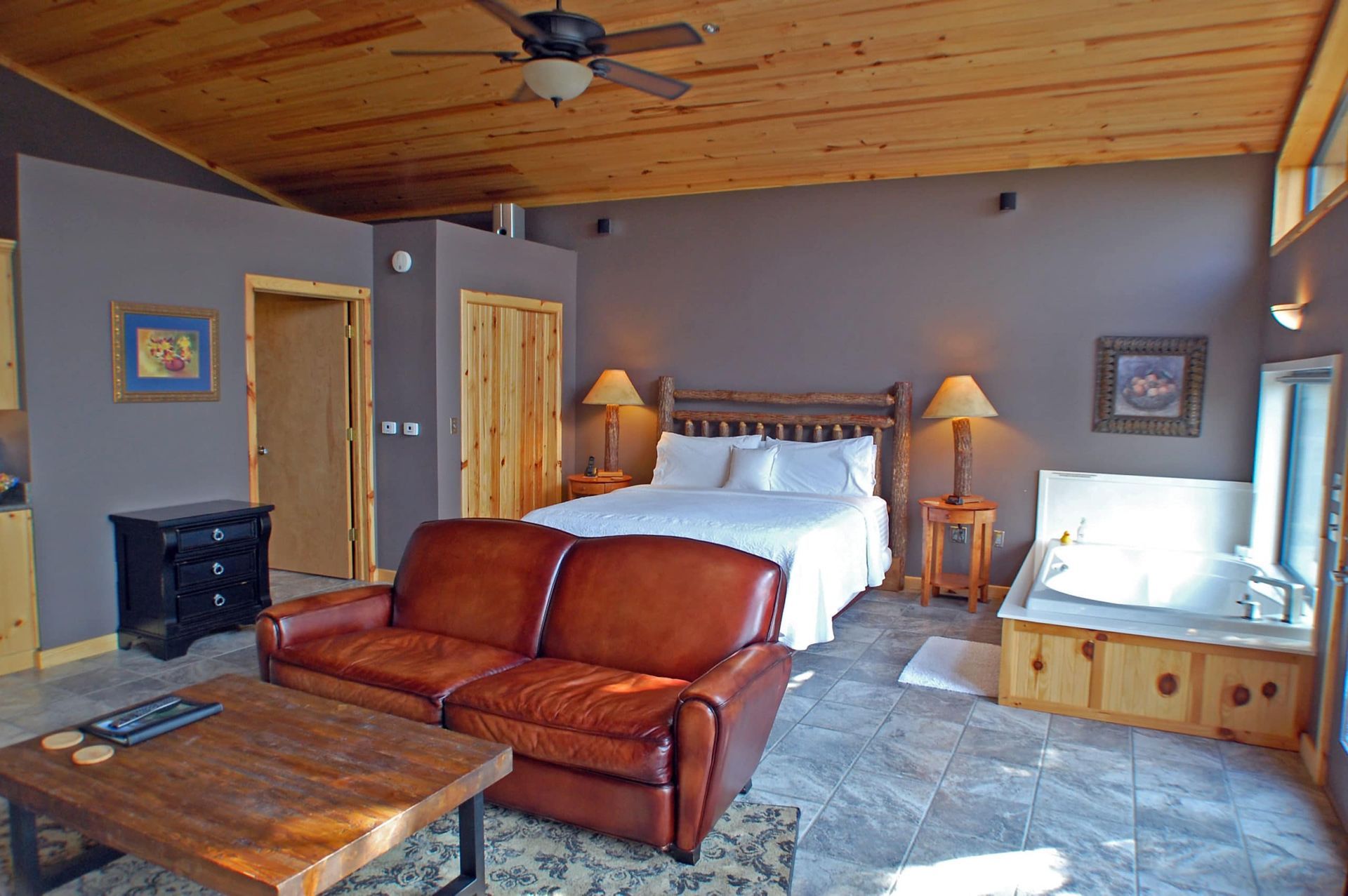 A living room with a bed , couch , coffee table and jacuzzi.