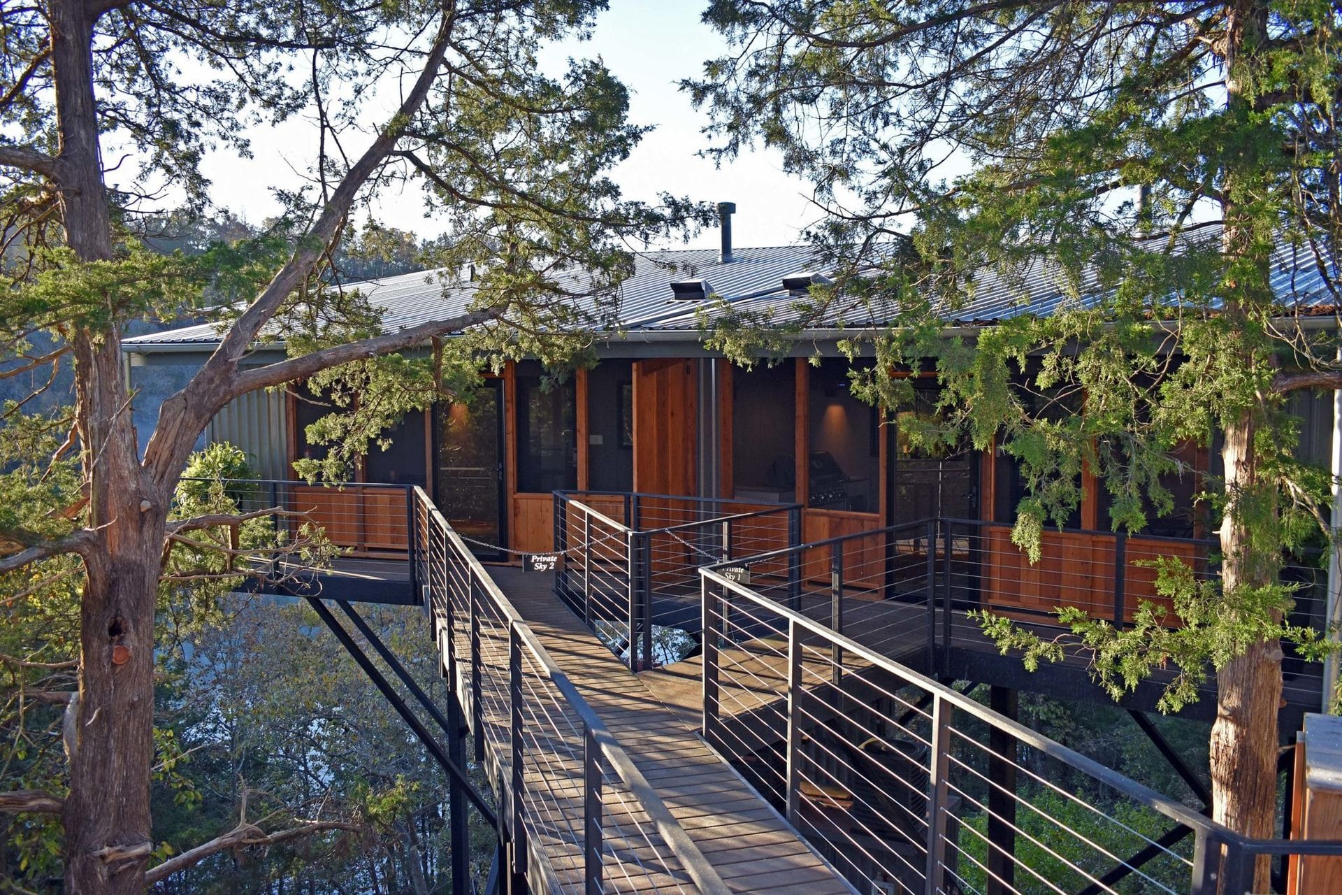 A house with a bridge leading to it surrounded by trees