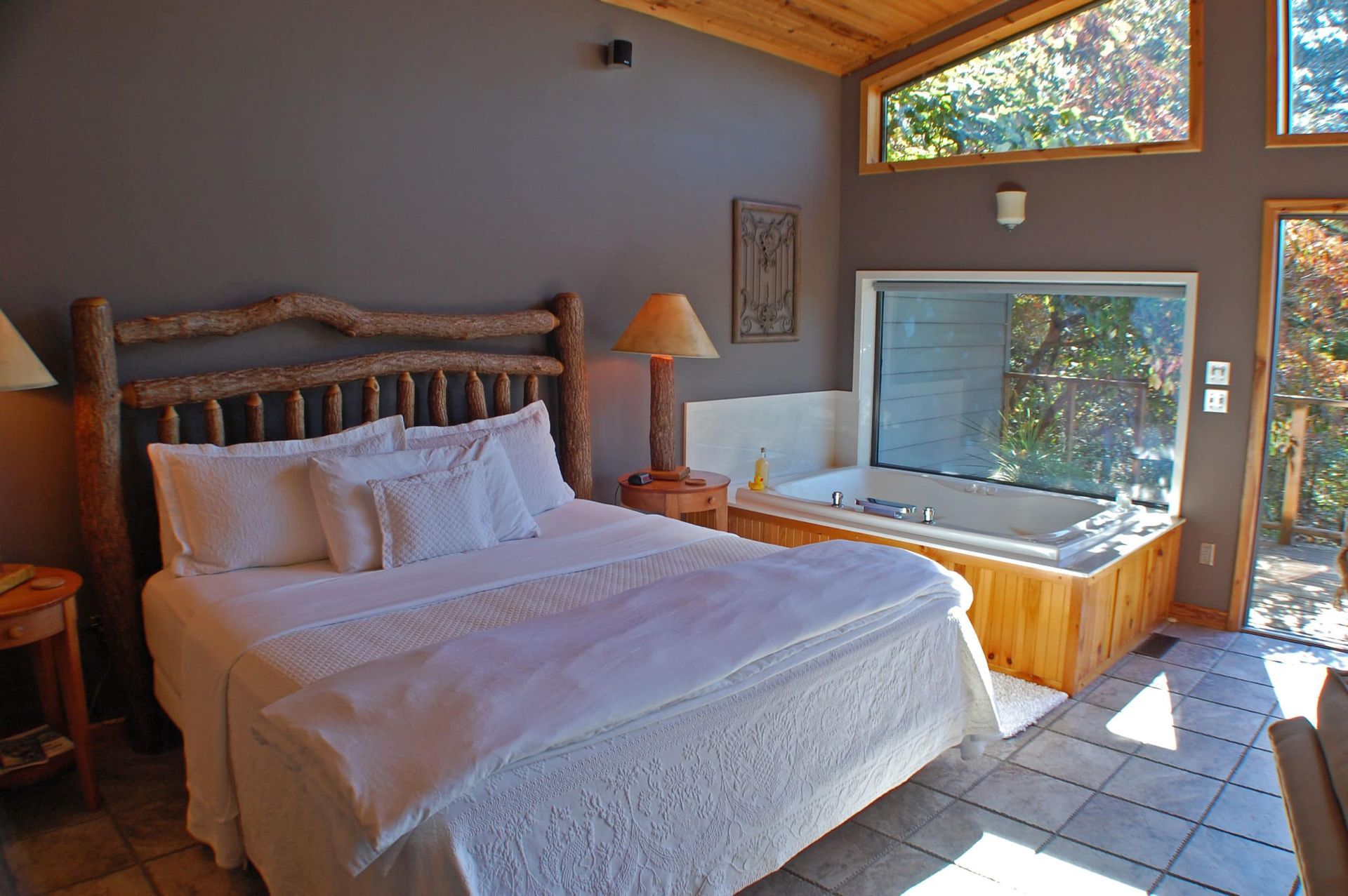 A bedroom with a large bed and a jacuzzi tub