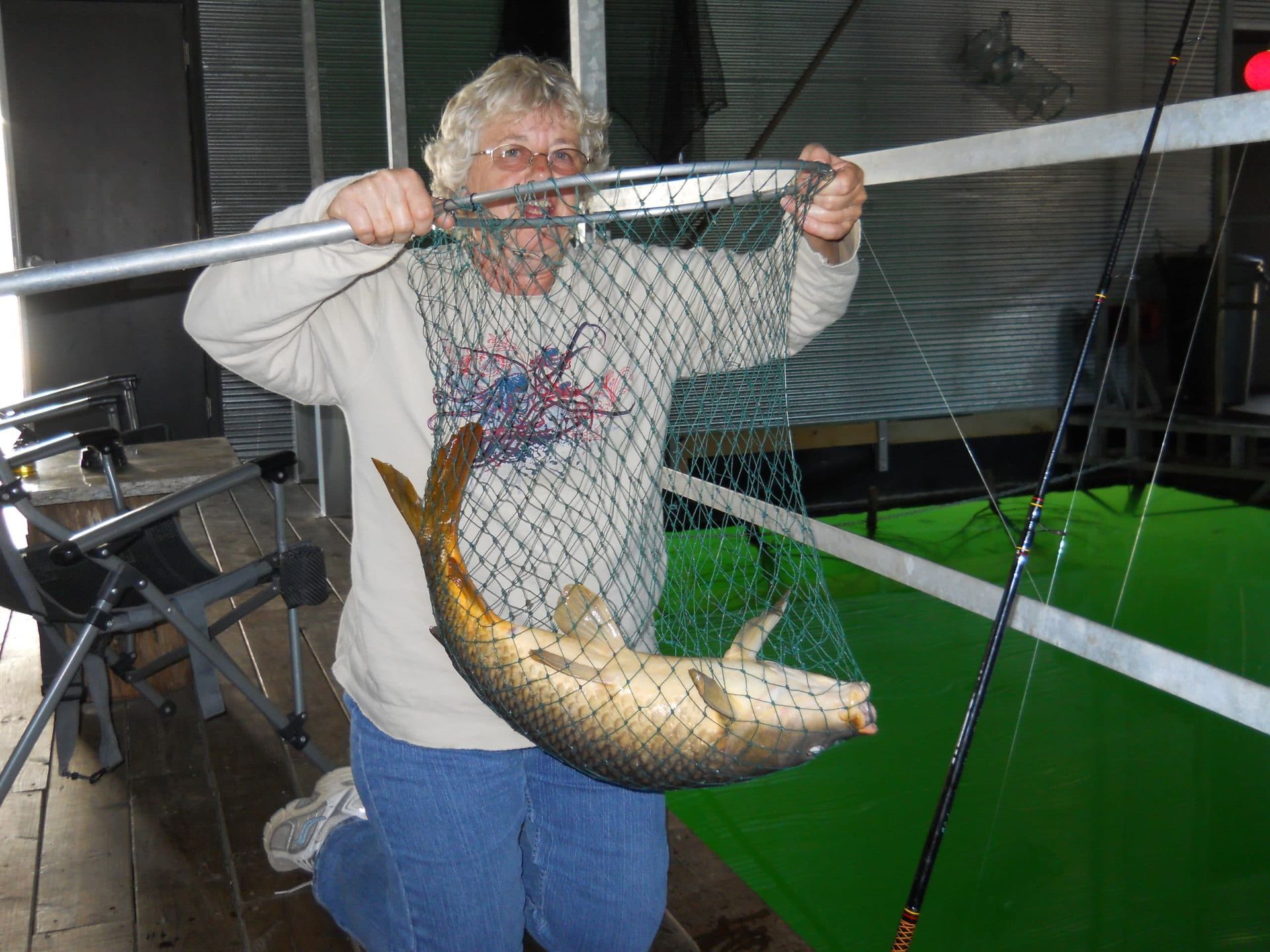 A man is holding a large fish in a net