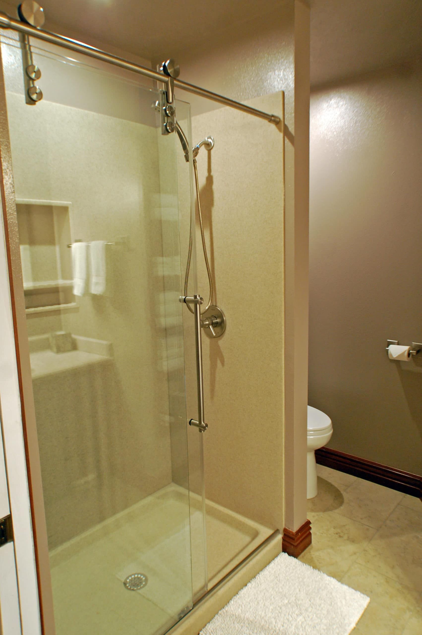 A bathroom with a walk in shower and a toilet