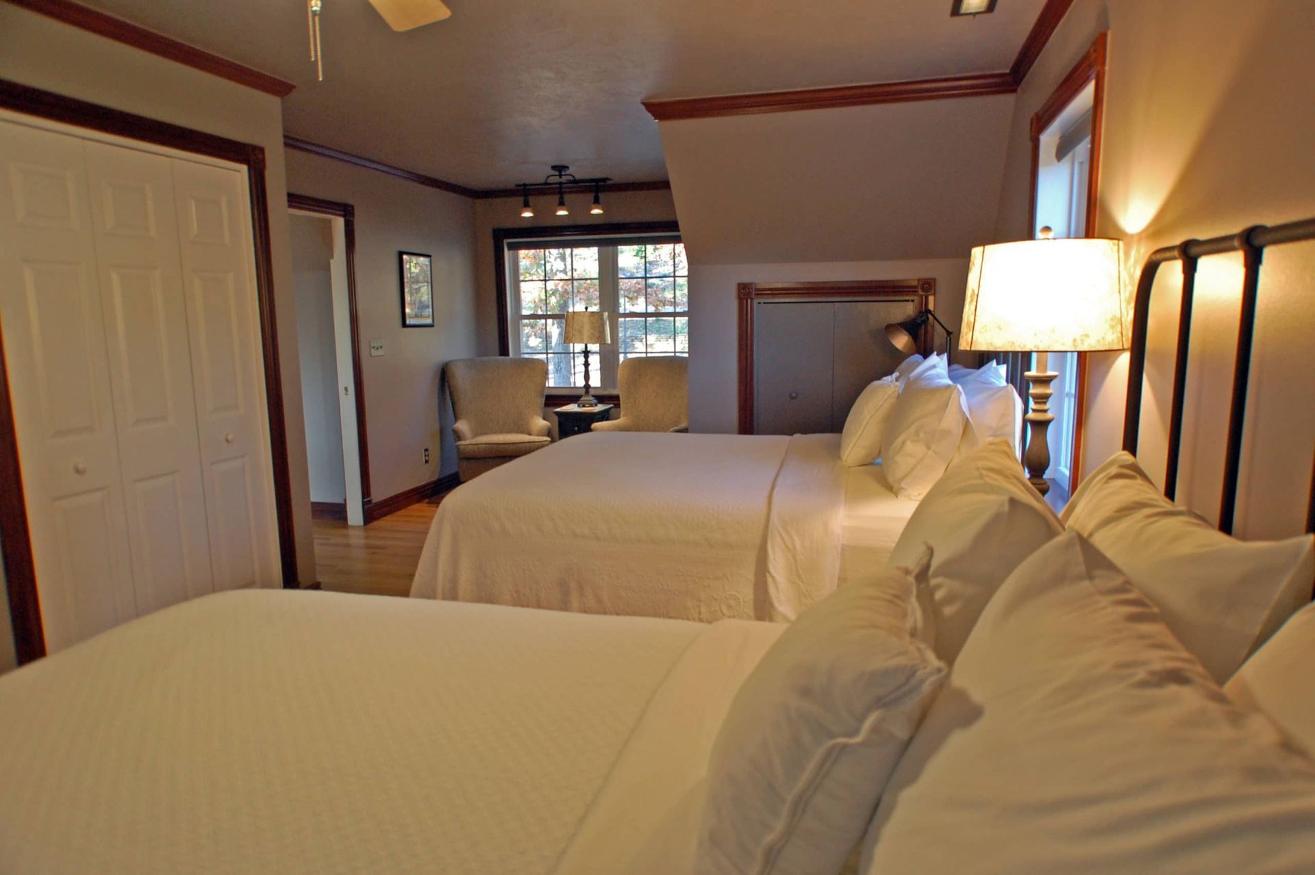 A hotel room with two beds and a ceiling fan