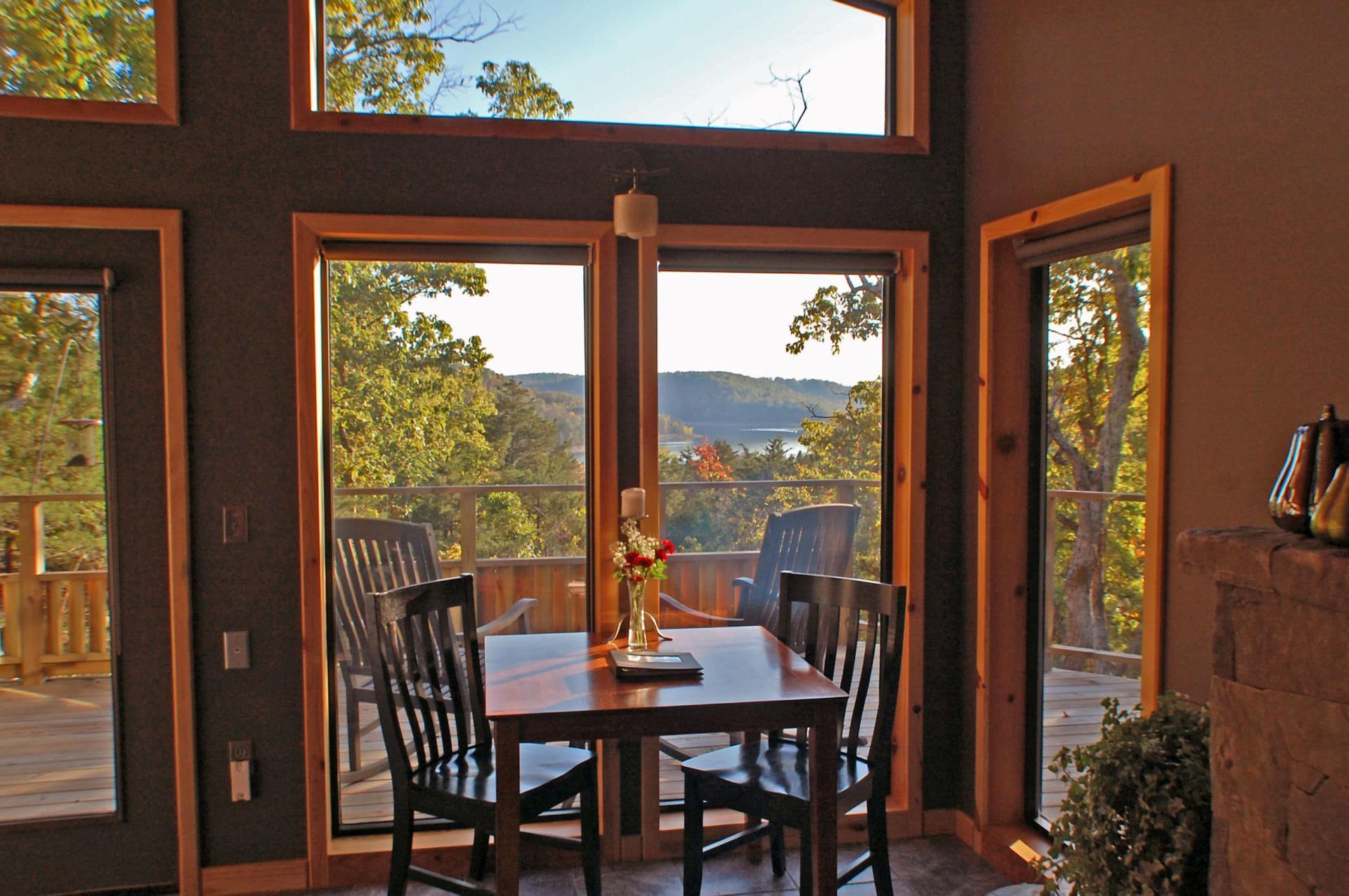 A dining room with a table and chairs and lots of windows