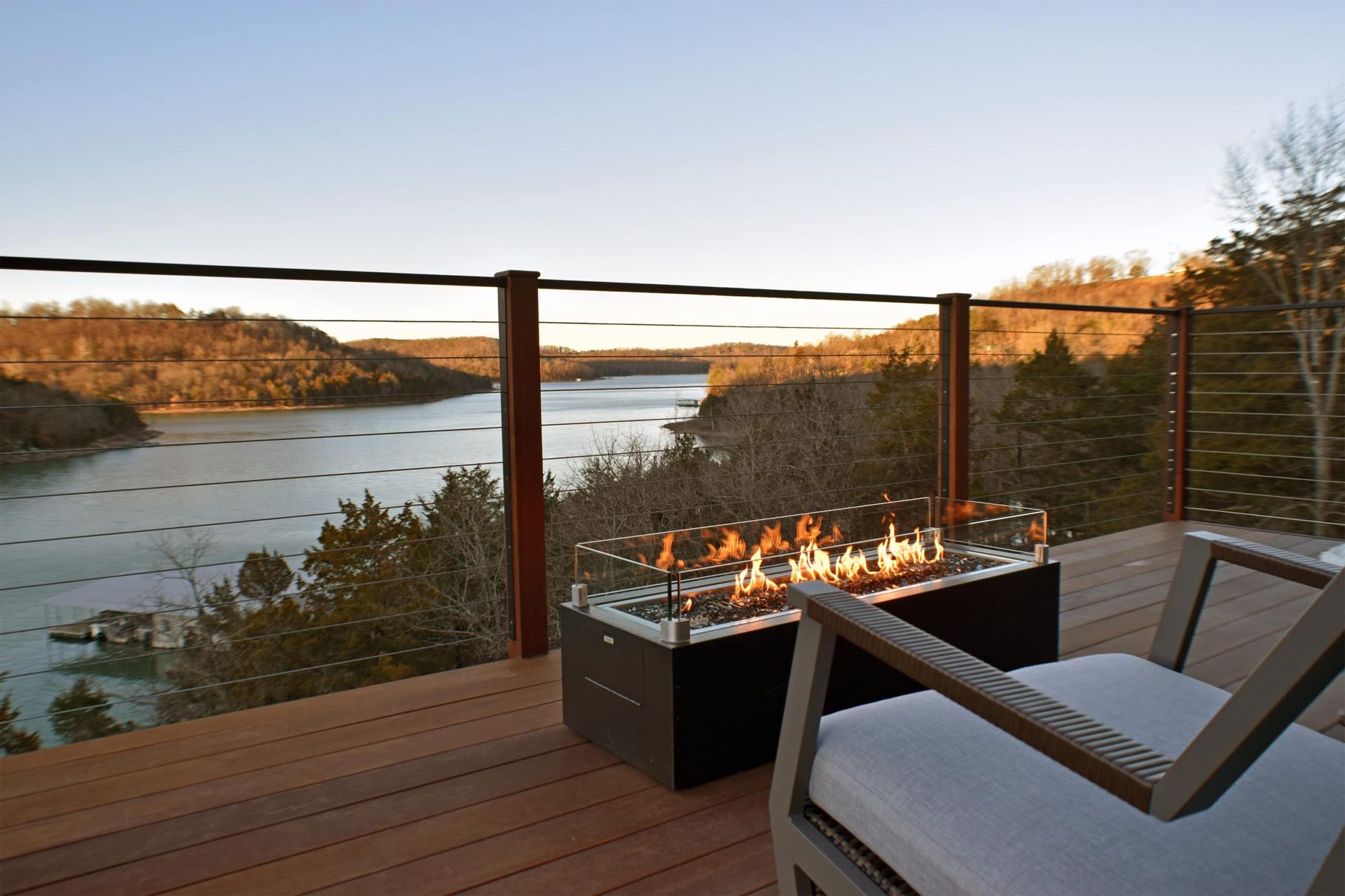 A fire pit on a deck overlooking a lake