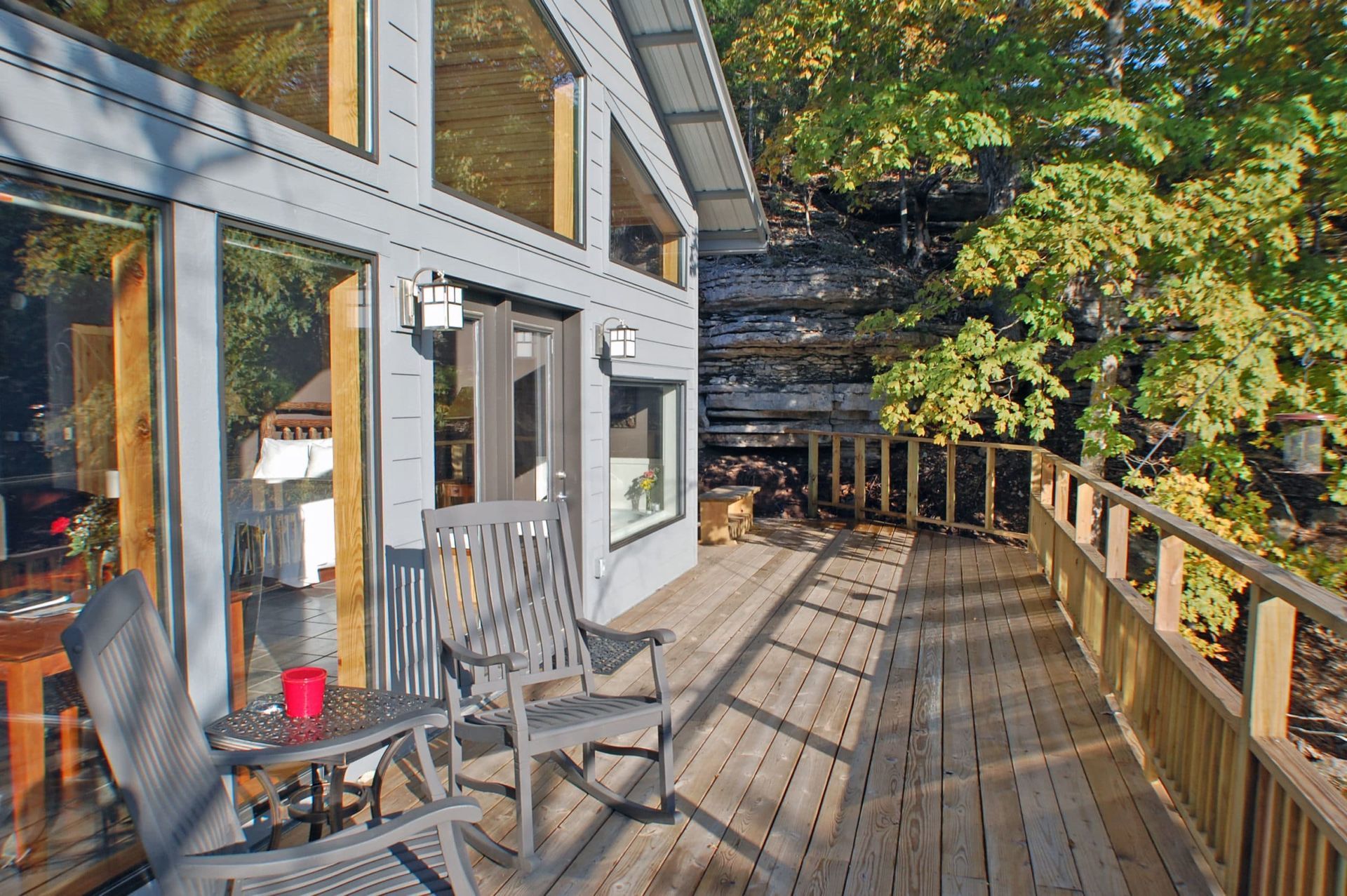 A wooden deck with rocking chairs and a table