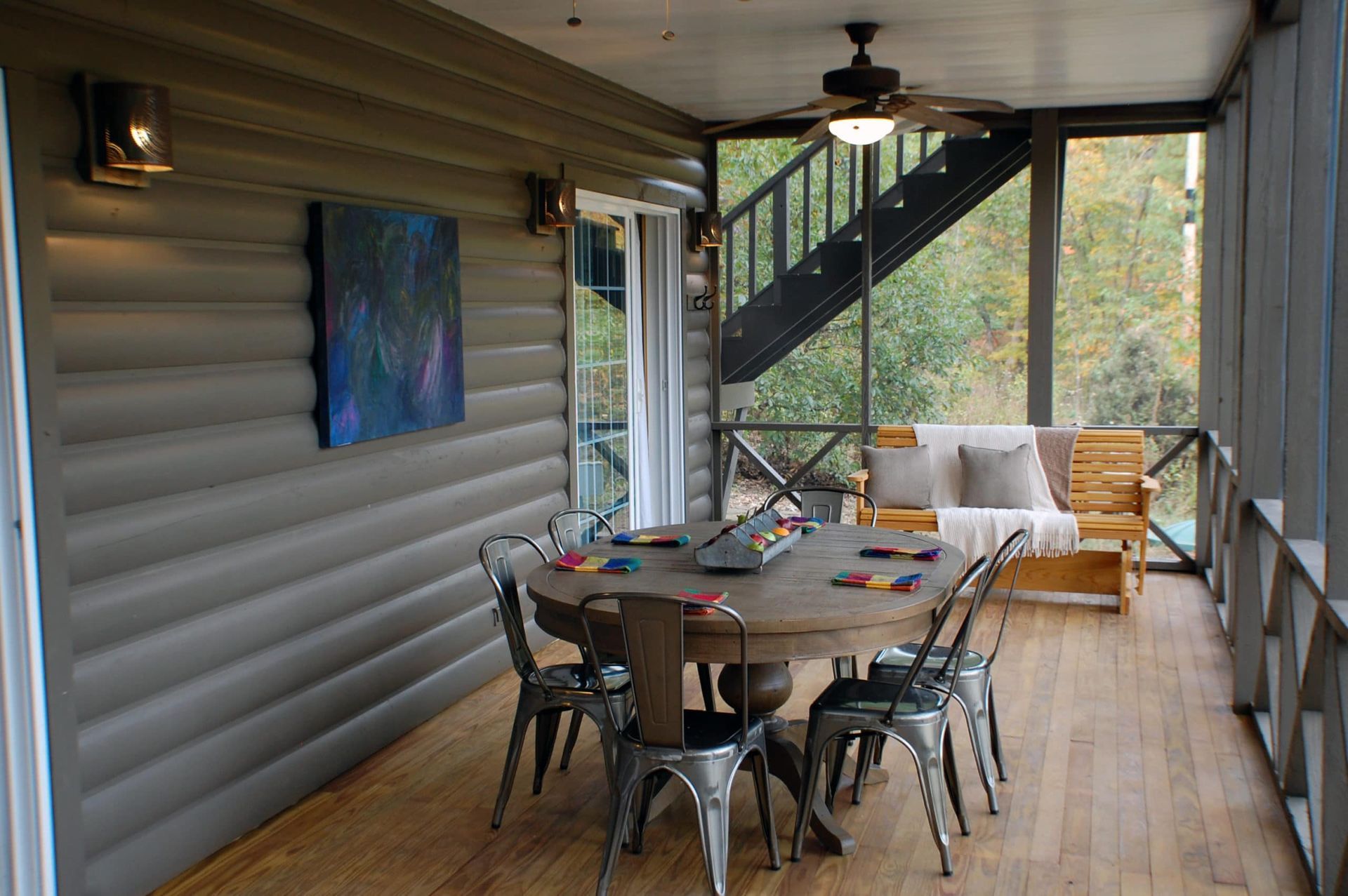 A screened in porch with a table and chairs