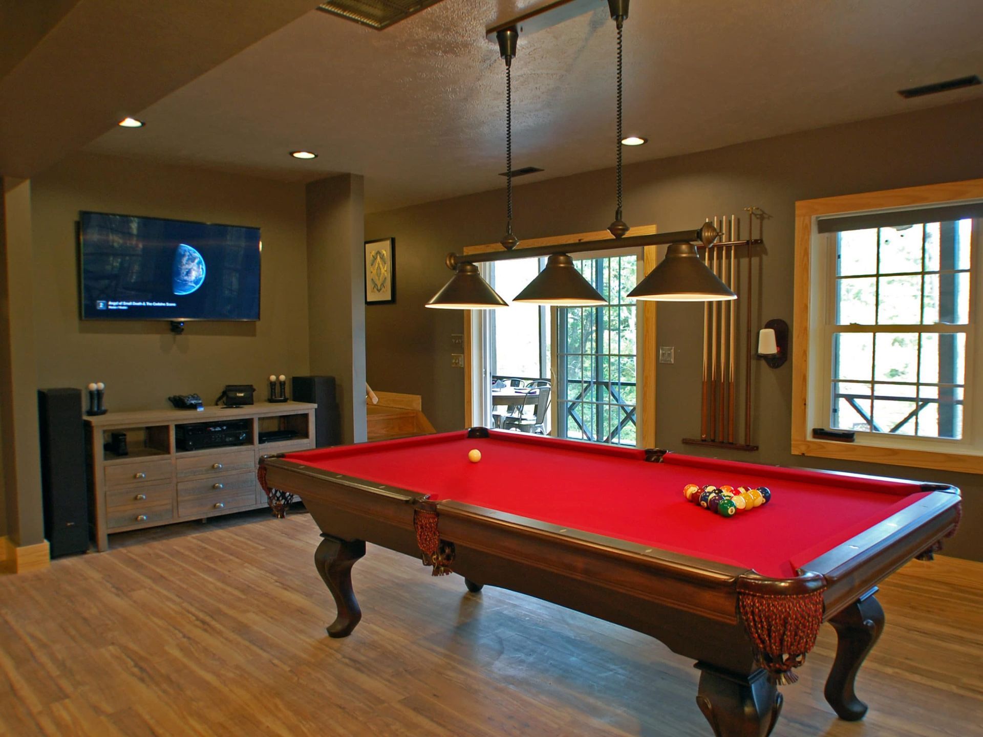 A pool table in a living room with a flat screen tv