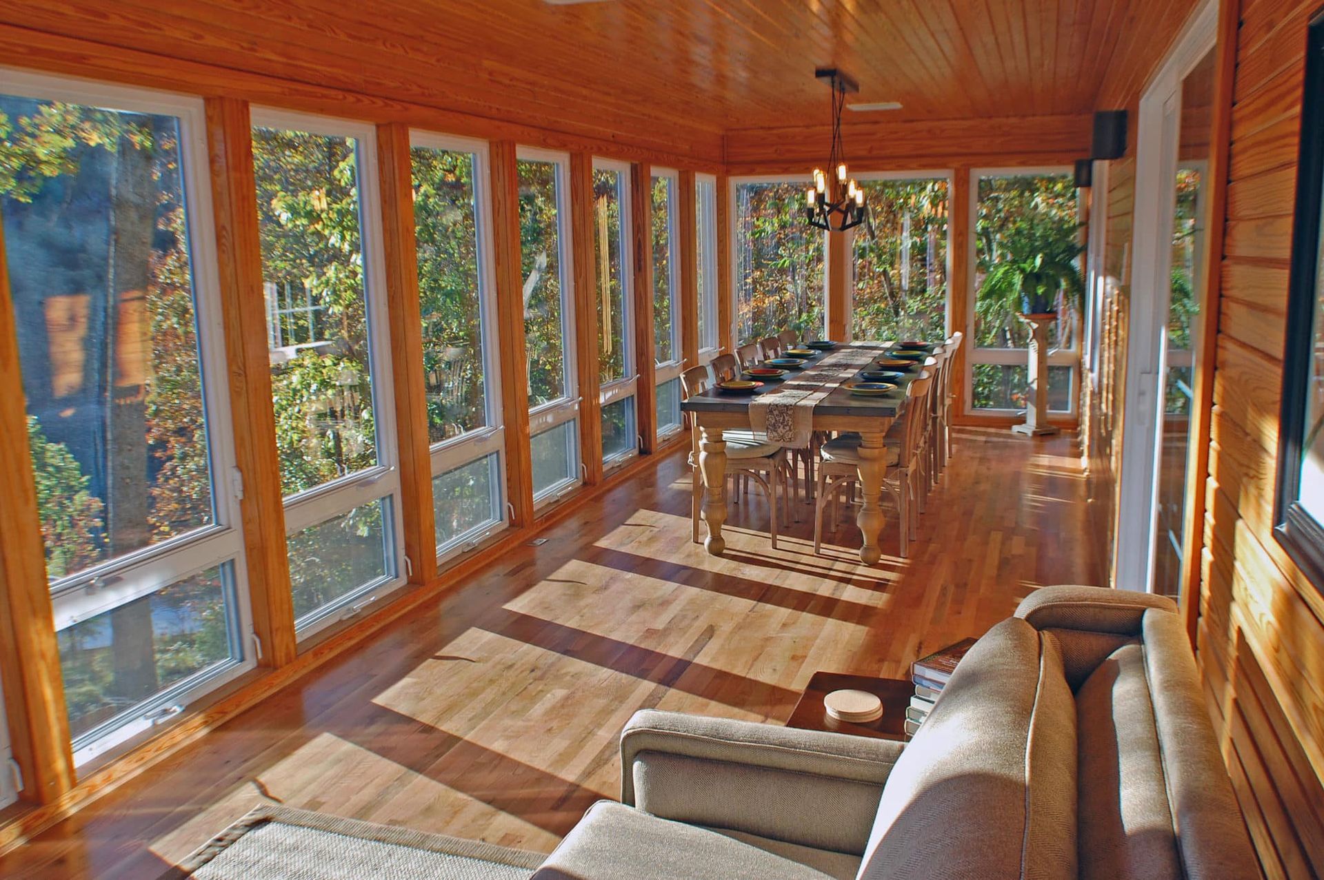 A screened in porch with a dining table and chairs