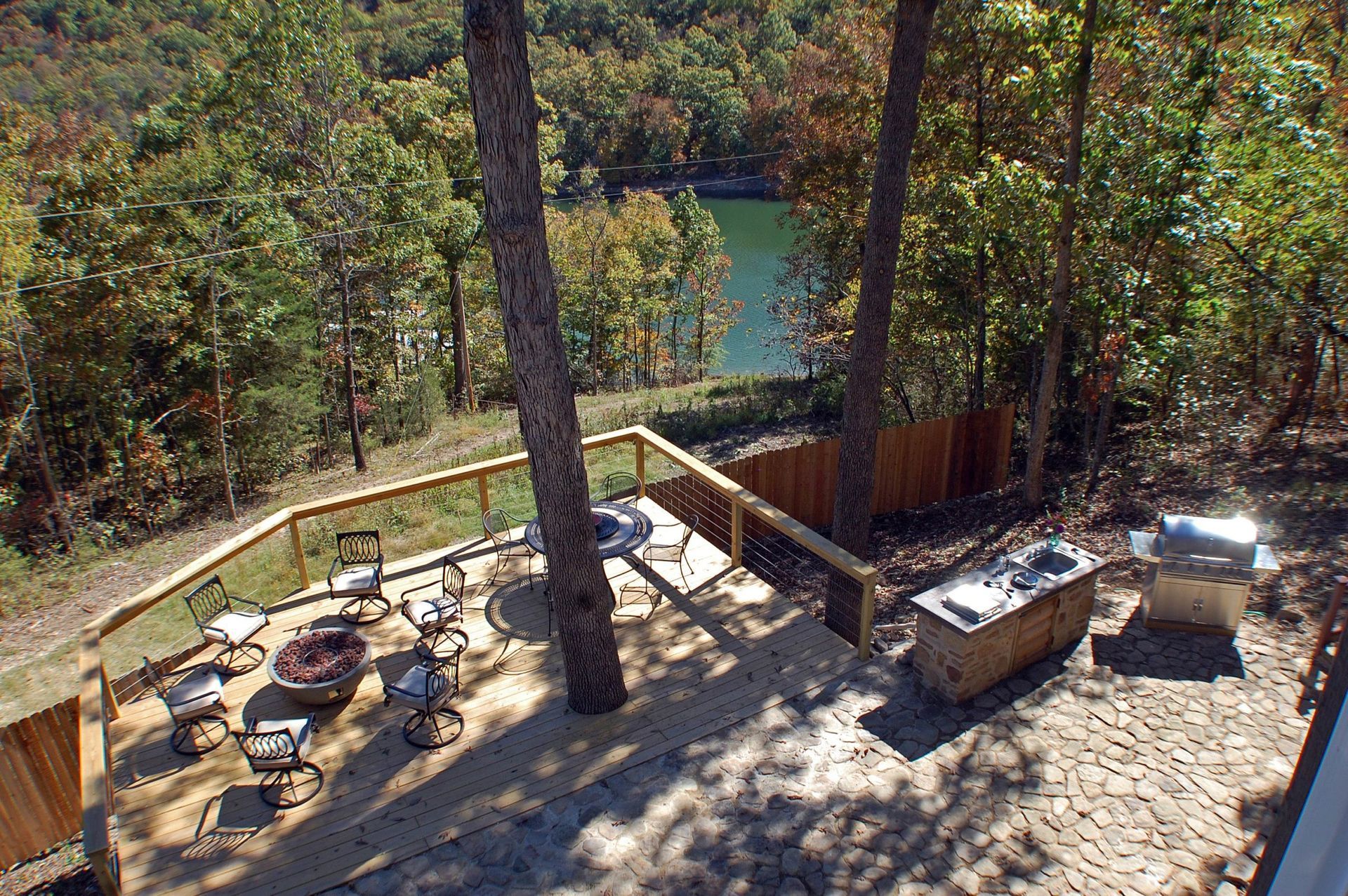 An aerial view of a deck with a fire pit and a lake in the background