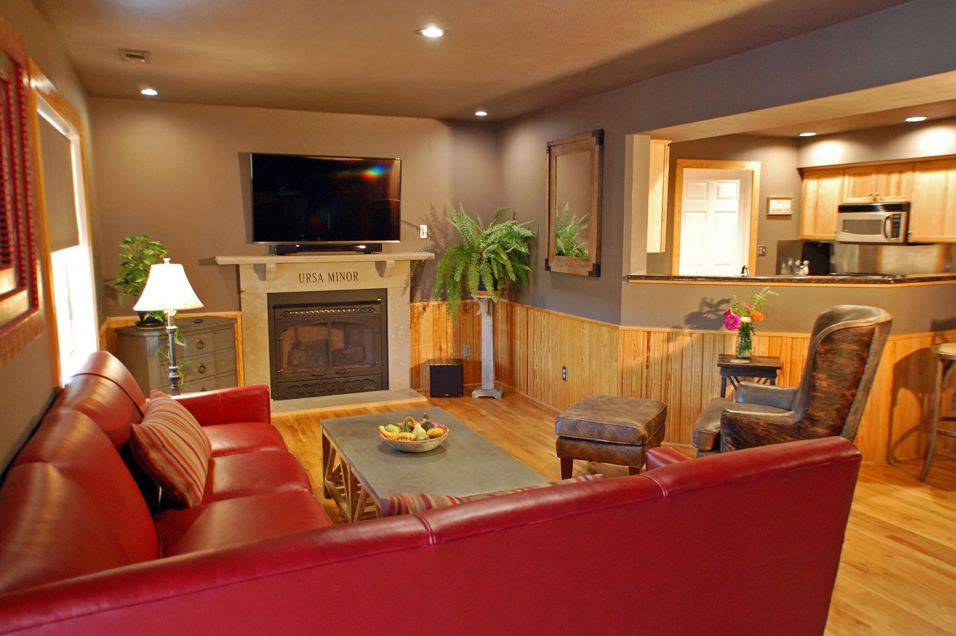 A living room with a red couch and a flat screen tv