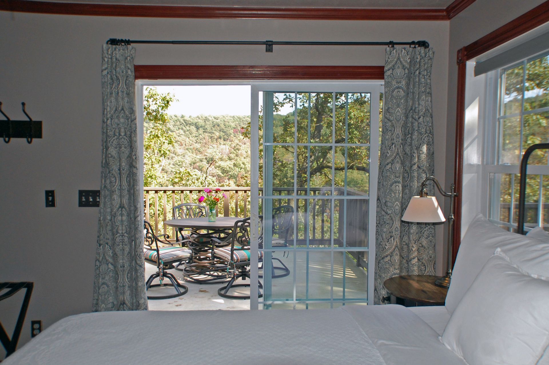 A bedroom with a sliding glass door leading to a balcony