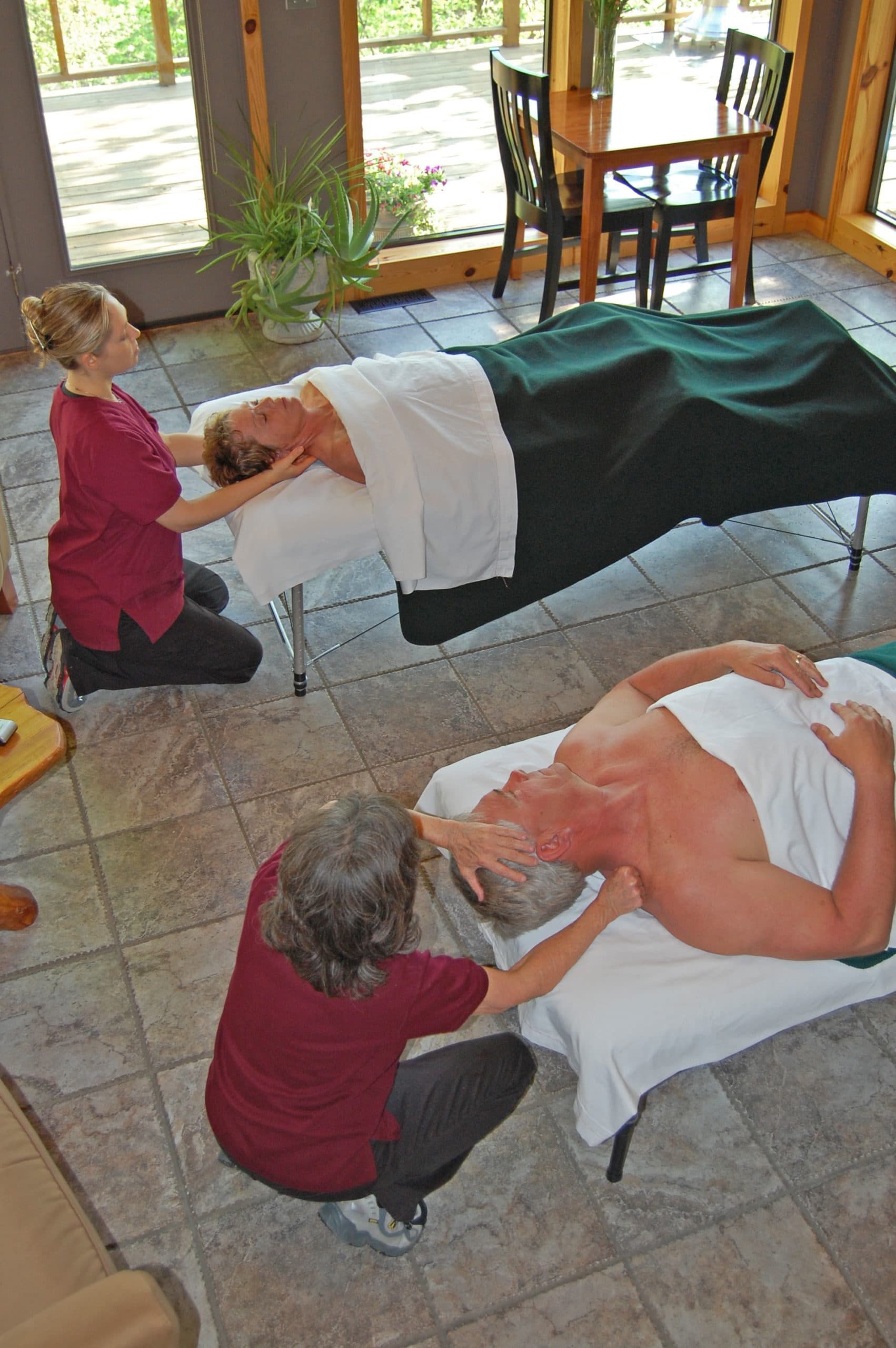 A man and a woman are getting a massage in a living room.