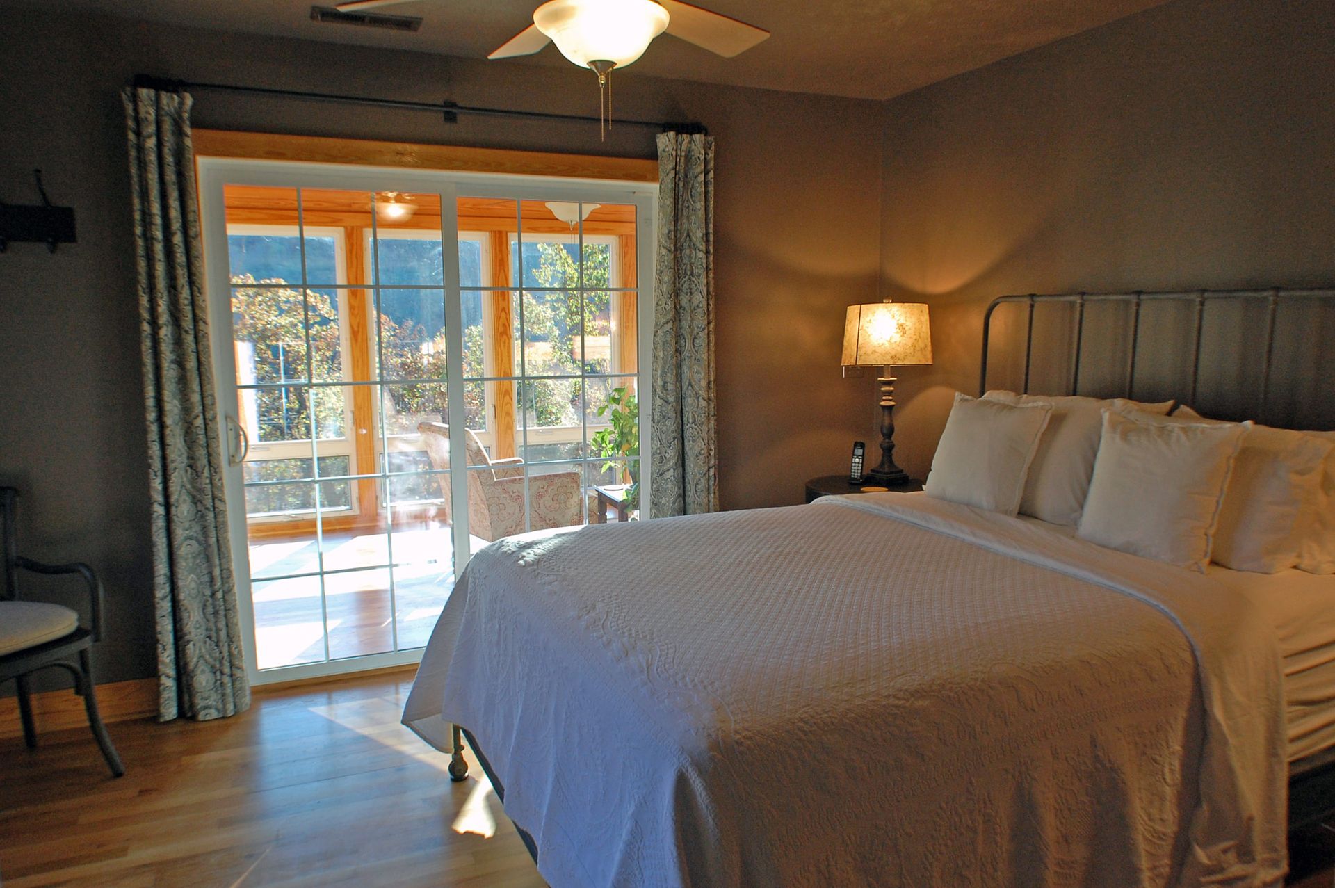 A bedroom with a large bed and a ceiling fan