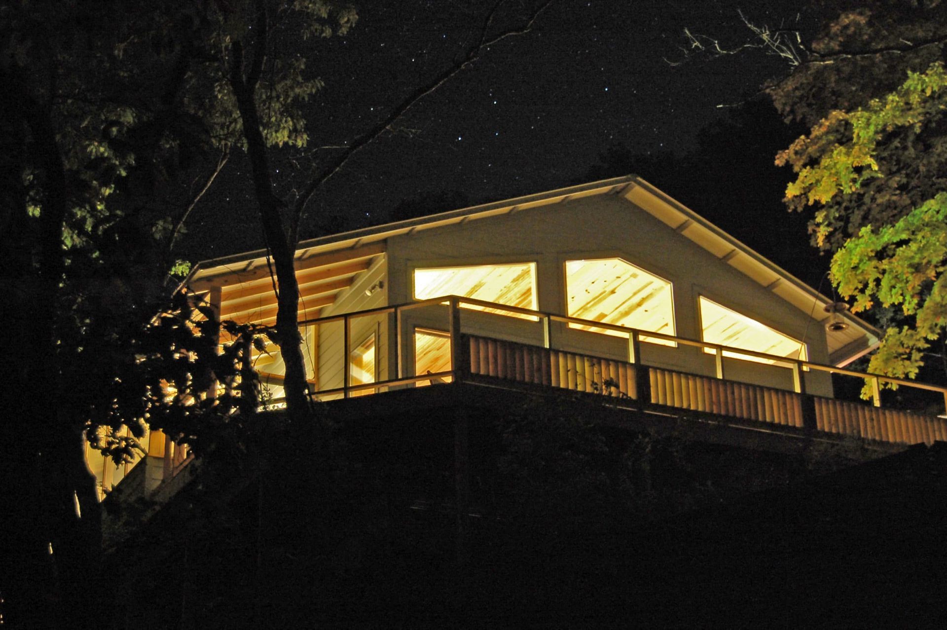 A house with a balcony is lit up at night