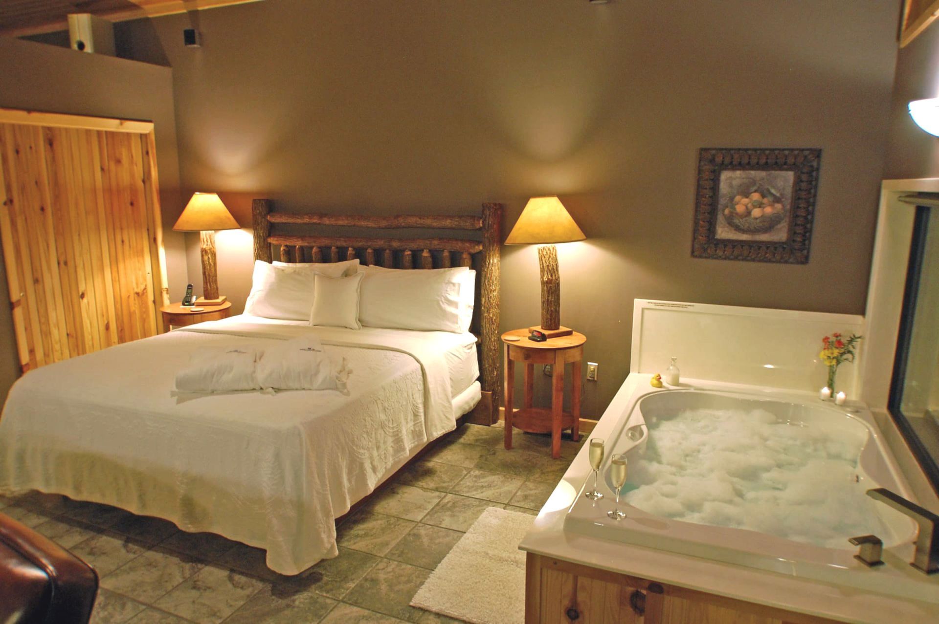 A bedroom with a king size bed and a jacuzzi tub.