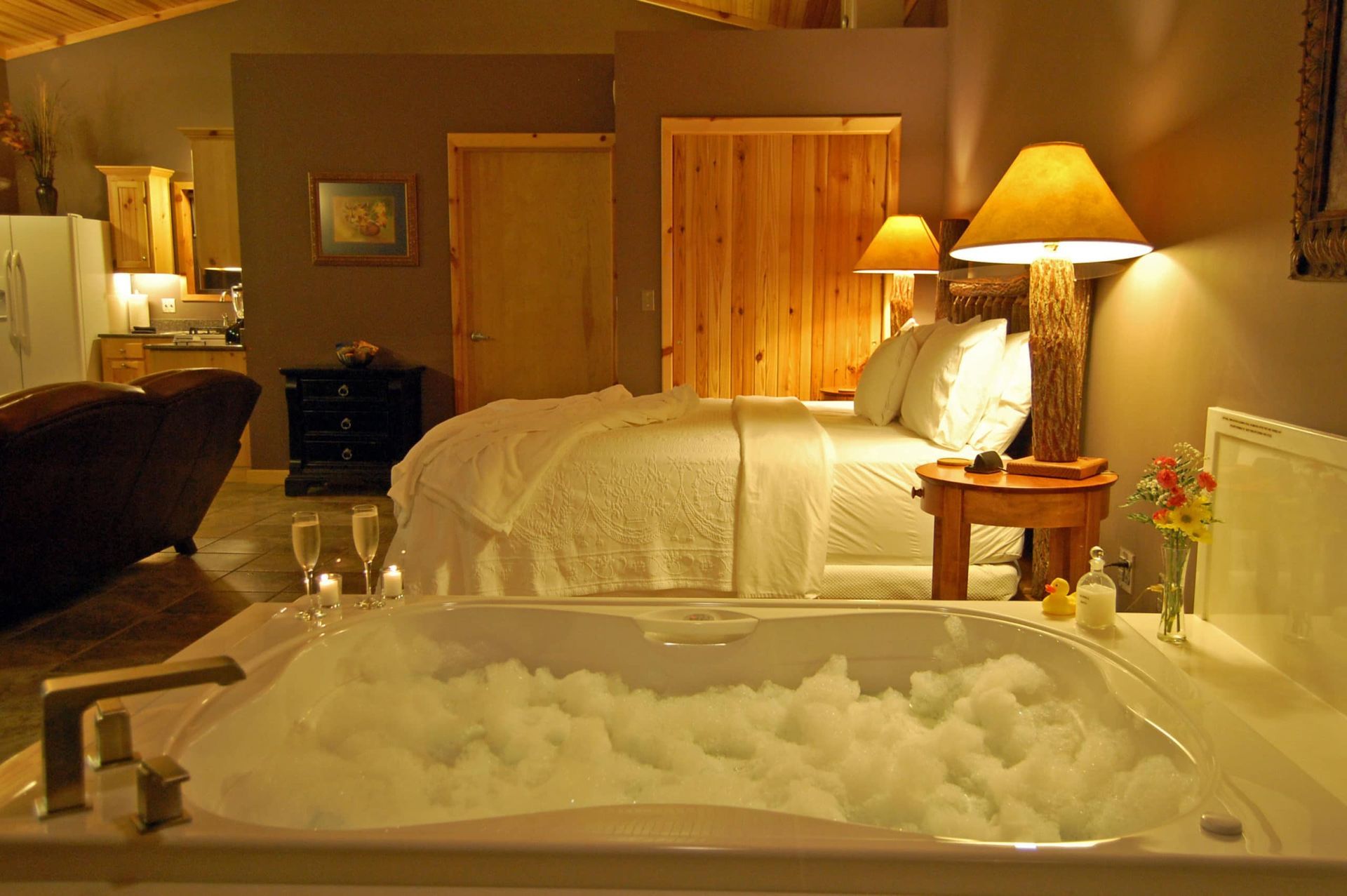 A bedroom with a jacuzzi tub and a bed