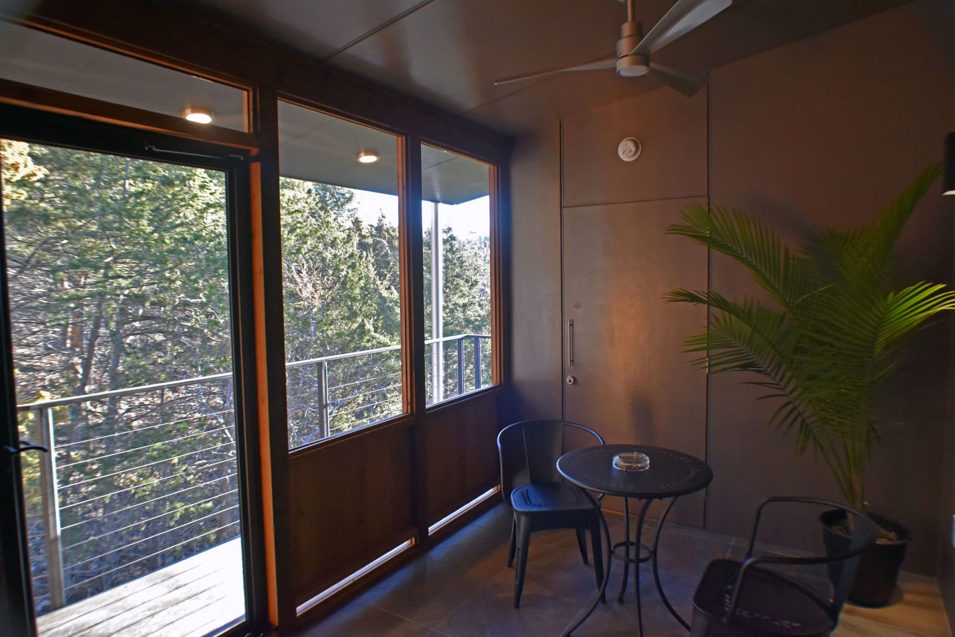A room with a table and chairs and a ceiling fan.