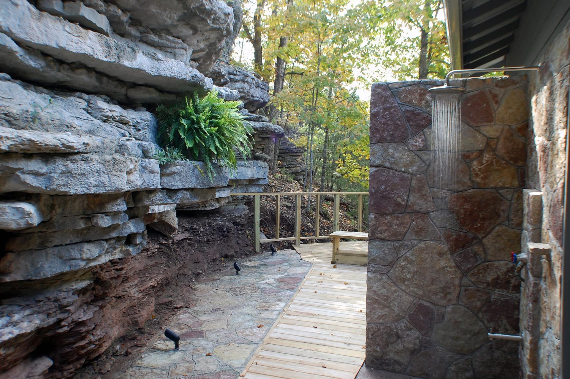 A stone wall with a wooden walkway leading to it