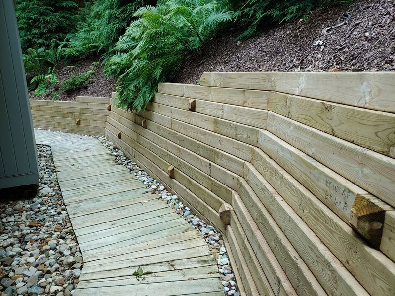 Wooden retaining wall and pathway leading uphill.