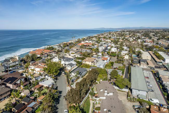 Aerial view of a coastal neighborhood beside the ocean on a sunny day